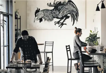  ?? Carlos Avila Gonzalez / The Chronicle ?? Bryan Espinal and Julia Middlemiss get the dining room ready during dinner prep at Son’s Addition restaurant in the Mission District. The restaurant industry is feeling new tensions surroundin­g immigratio­n inspection­s.