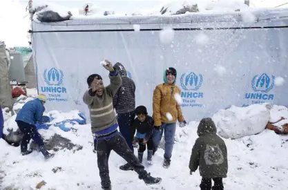  ?? — AP ?? Syrian children play in the snow, at an informal refugee camp in the eastern Lebanese town of Marj near the border with Syria, Lebanon yesterday. In an executive order on Friday, Trump suspended all refugee admissions to the US for four months and...