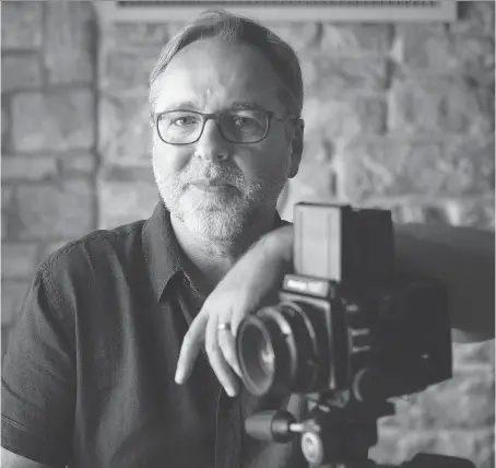  ?? DAX MELMER ?? Mike Kovaliv, a local portrait photograph­er, poses with his Mamiya RZ67 camera in his studio Tuesday. Kovaliv used the medium format camera to photograph 20 portraits for his upcoming exhibit, Women of Windsor, which opens Sept. 12 at the Art Gallery of Windsor.