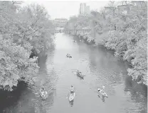  ??  ?? People in canoes and on paddleboar­ds move down Barton Creek in Austin, Texas, on Apr 3, 2015.