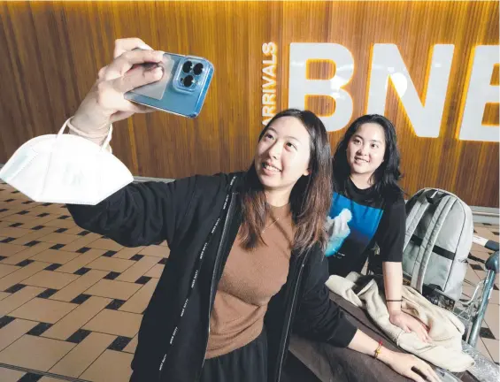  ?? Picture: Richard Walker ?? Serena Xiong and Clare Chen grab the chance to take a selfie at the Brisbane Airport arrivals gate.