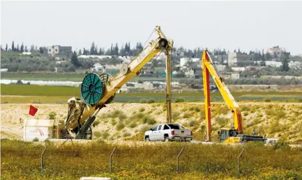  ?? (Amir Cohen/Reuters) ?? CONSTRUCTI­ON WORK is underway on the Israeli side of the border with the Gaza Strip yesterday.