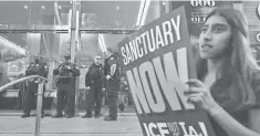  ?? FREDERIC J. BROWN, AFP/ GETTY IMAGES ?? Department of Homeland Security officers stand guard in front of the Los Angeles Immigratio­n Court building as protesters gather in March after the high- profile arrest of Romulo Avelica- Gonzalez, a Mexican who lived in the USA for 27 years. He was...