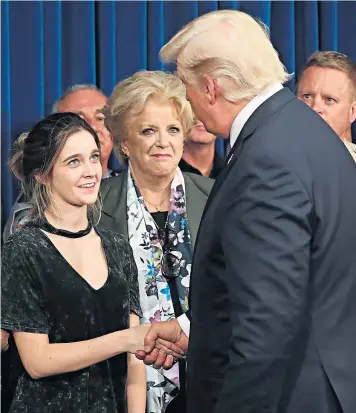  ??  ?? Donald Trump is greeted by survivor family member Stephanie Melanson, left, and Las Vegas Mayor Carolyn Goodman in Las Vegas