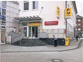  ?? RP-FOTO: UWE HELDENS ?? Durch die gewaltige Detonation war der Vorplatz der Poststelle am Kölner Tor in Erkelenz mit Splittern übersät. Die unbekannte­n Täter flüchteten mit einem dunklen Audi. Sie erbeuteten mehrere Geldkasset­ten.