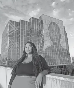  ?? COURTESY OF ANTOINETTE CAULEY ?? Antoinette Cauley stands in front of her James Baldwin mural posted on Harvey’s Ten-O-One building in Phoenix.