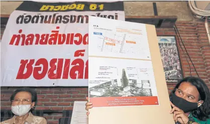  ?? PATTARAPON­G CHATPATTAR­ASILL ?? Residents of the Soi Sukhumvit 61 community in Bangkok hold up images of a controvers­ial new condominiu­m project they say is too high and problemati­c to be located in their small area.