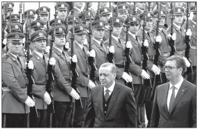  ?? AP/DARKO VOJINOVIC ?? Turkish President Recep Tayyip Erdogan (front left) reviews an honor guard with Serbian President Aleksandar Vucic during a welcoming ceremony Tuesday for Erdogan in Belgrade.