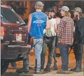  ?? MORRY GASH/AP ?? An armed group watches protesters Tuesday night in Kenosha, Wis., two days after the shooting of Jacob Blake.