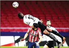  ?? AFP ?? Valencia’s French defender Mouctar Diakhaby (top) heads the ball in the La Lige football match against Atletico Madrid on Sunday.