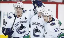  ?? CANADIAN PRESS FILE PHOTO ?? Vancouver Canucks’ Bo Horvat, left, celebrates his goal with Elias Pettersson, centre, and Sven Baertschi against Calgary on Oct. 6.The Canucks are one of three Canadian teams exceeding expectatio­ns.