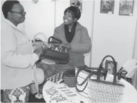  ??  ?? Mrs Thenjiwe Dube (right) of Moving Mothers shows Mrs Ainah Kaguru handbags that they make at their stand at the Zimbabwe Internatio­nal Trade Fair last Wednesday