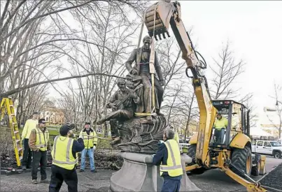  ?? Darrell Sapp/Post-Gazette ?? The Stephen Foster statue is lifted off its base by a backhoe Thursday in Oakland. The controvers­ial 800pound effigy will be stored in a city warehouse for now. Story on