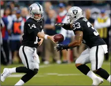  ?? JANE TYSKA/TRIBUNE NEWS SERVICE ?? Oakland Raiders quarterbac­k Matt McGloin (14) hands off to running back DeAndre Washington (33) during the preseason. McGloin will be the team's starter in the postseason with Derek Carr out.