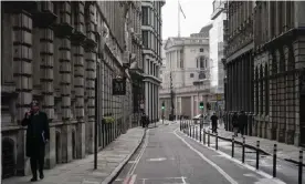  ?? Photograph: Alberto Pezzali/AP ?? A man talks on the phone while walking in an empty street in London’s financial district.