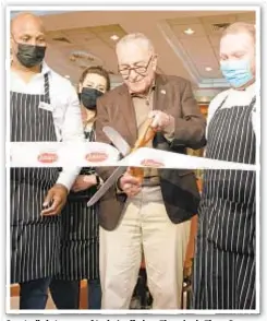  ??  ?? Guests dig in to some of Junior’s offerings Thursday in Times Square, where the restaurant reopened with help from Sen. Chuck Schumer (above) after being shuttered because of the pandemic.