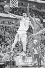  ?? Charles Rex Arbogast / Associated Press ?? Gerald Green (14) glides past the Bulls’ Justin Holiday to score two of his 22 points during his latest impressive performanc­e since joining the Rockets.