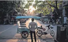  ?? ?? Warten auf Fahrgäste: Tuk-Tuks sind eine Möglichkei­t, um von Siem Reap zu den Tempeln zu kommen. Aber die Touristen sind noch nicht zurückgeke­hrt.