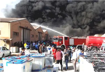  ??  ?? Smoke rises from a storage site in Baghdad, housing ballot boxes from the May parliament­ary election. — Reuters photo