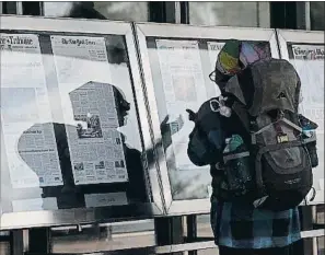  ?? AFP ?? Una mujer lee las portadas expuestas en el Newseum (Washington)