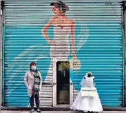  ??  ?? A vendor of dresses for brides protests with mannequins in the streets of Mexico City. Shopkeeper­s are urging the government to relax Covid curbs and allow them open their stores.