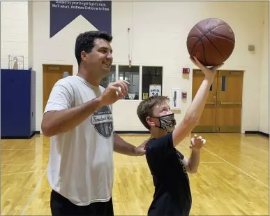  ?? MARAH MORRISON — THE NEWS-HERALD ?? Rudy Kirbus, varsity boys basketball coach at the Andrews Osborne Academy in Willoughby, instructs Jackson Sharpless, a rising sixth grader.