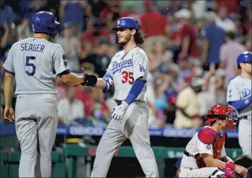  ?? Matt Slocum Associated Press ?? DODGERS’ CODY BELLINGER, center, celebrates with Corey Seager, left, after hitting a two-run home run off Philadelph­ia Phillies pitcher Kyle Gibson during the fourth inning. The Dodgers went on to win 8-2.