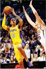  ?? AP PHOTO BY ROSS D. FRANKLIN ?? Los Angeles Lakers forward Kyle Kuzma (0) drives past Phoenix Suns forward Dragan Bender, right, during the first half of an NBA basketball game Monday in Phoenix.