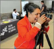  ?? NWA Democrat-Gazette/ANDY SHUPE ?? Sonia Gutierrez, founder and chief operating officer of New Design School in Fayettevil­le, photograph­s Brian Dodwell of Fayettevil­le on Thursday during Tech Fest in the Fayettevil­le Town Center. New Design School operates out of a shared space with...
