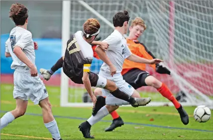  ?? SEAN D. ELLIOT/THE DAY ?? Stonington High School’s Jamison Magowan, second from left, goes flying as he collides with New Fairfield defenders Christophe­r Savits, left, and Christophe­r Connor, center, and goalie Braden Quinn in front of the goal during the first half of a CIAC Class M boys’ soccer game Tuesday at Palmer Field in Stonington. The third-seeded Bears rolled to the 5-0 win over the 30th-seeded Rebels in the first-round game.