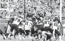  ?? RICK OSENTOSKI, USA TODAY SPORTS ?? Michigan defensive end Chris Wormley (43) blocks a field goal attempt by Central Florida’s Matthew Wright on Saturday.