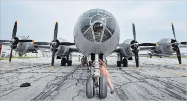  ??  ?? A crew member loads items into the cockpit of B-29 Superfortr­ess as it prepares to take off at Windsor airport.