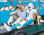 ?? DOUG MURRAY Associated Press ?? THE DOLPHINS’ Tua Tagovailoa is carted off the field after he suffered a rib injury in a loss to the Bills.