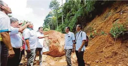  ?? [FOTO RAMDZAN MASIAM/BH] ?? Nor Akhirrudin (tiga dari kiri) melihat antara 53 lokasi tanah runtuh yang dikesan ketika meninjau kawasan mengalami kerosakan hutan akibat hujan serta angin kencang dua minggu lalu di Taman Rimba Bukit Mertajam, Pulau Pinang, semalam.