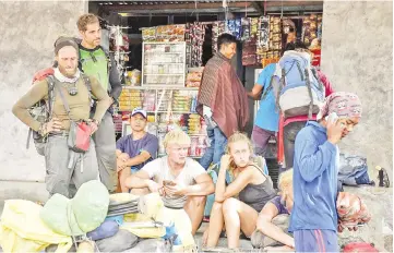  ??  ?? Indonesian and foreign climbers are seen after walking down from Rinjani Mountain at Sembalun village in Lombok Timur. — Reuters photo