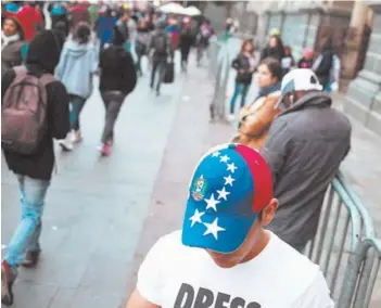  ??  ?? ► Migrantes en el sector de Plaza de Armas, de Santiago.