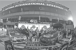  ?? TERRY RENNA / AP ?? Dale Earnhardt Jr., center left and Chase Elliott, center right, display their front row trophies with their crews after qualifying for the top two positions in the Daytona 500 on Sunday at Daytona Internatio­nal Speedway.