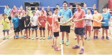  ??  ?? Ng (right), Indonesian coach Andre Wijaya (centre) and fellow trainees giving Zi Suen a warm welcome upon her return to training on Monday.