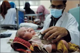  ?? ?? A doctor examines a malnourish­ed child Sunday in the Indira Gandhi hospital.