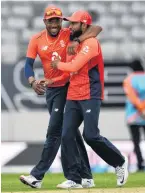  ??  ?? Black Cap Martin Guptill leaves the field after the match; (right) England’s Chris Jordan and Adil Rashid celebrate.