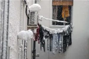  ?? The Associated Press ?? Frozen laundry hangs on a line outside an apartment window after a heavy snowfall in Madrid, Spain, on Saturday. Spain is on high alert as a cold snap is covering much of the country with snow disrupting road, sea, rail and air traffic with the capital, Madrid, enduring what the city’s mayor described as “the worst storm in 80 years.”