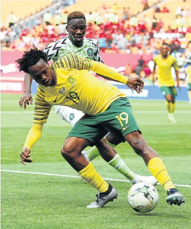  ?? Picture: PHILL MAGAKOE / AFP ?? IN CONTROL: South Africa’s Percy Tau vies for the ball with Nigeria’s Kenneth Omerou during their African Cup of Nations qualifier match in Johannesbu­rg on Saturday