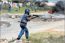  ??  ?? SHOW OF FORCE: Police use stun grenades and teargas to reopen the main Uitenhage road