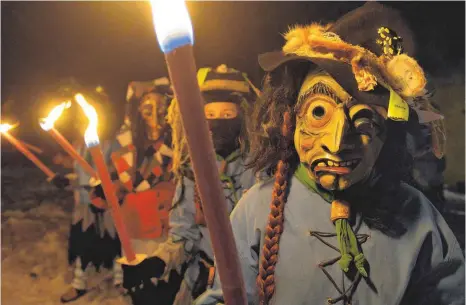  ?? FOTOS: KLAUS WEISS ?? Gespenstis­ch im Fackelsche­in tauchten die Masken aus dem Dunkel auf.