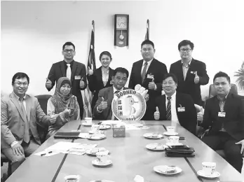  ??  ?? Abdul Karim holds the festival logo while Harry (seated left), Zabariah (seated second left), Ting (seated second right) and the organising committee members give their thumbs-up to the event.