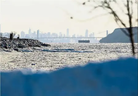  ?? — AFP ?? Icy river: New York city seen across the frozen Hudson River in Dobbs Ferry, New York.
