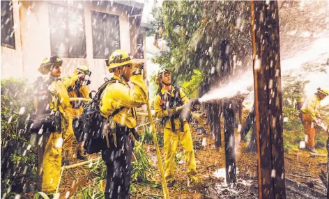  ?? Photos by Gabrielle Lurie / The Chronicle ?? Above: Firefighte­r Justin Pease hoses down a spot fire to protect a house in Windsor. At least 31 homes have been lost to the Kincade Fire despite the best efforts of fire crews.