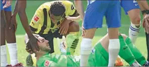  ?? (AFP) ?? Dortmund’s English midfielder Jude Bellingham attends to injured Hertha Berlin’s German goalkeeper Marcel Lotka during their Bundesliga match in Dortmund on Saturday.