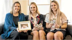  ?? VANESSA LAURIE/STUFF ?? Taranaki high school students Meg MacDonell, centre, and Brooke Hoskins have donated 30 packs of Ora Cards to Gabby’s Starlit Hope charity’s Sarah Devine, left.