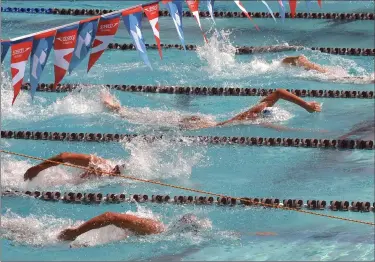  ?? Dan Watson/ The Signal ?? (Above) Attendees watch the swimming competitio­ns during the SPEEDO Summer Sectionals held at The Santa Clarita Aquatic Center in Santa Clarita on Friday. (Left) Swimmers compete in Men’s 200-meter freestyle event. Canyons Aquatics Club swimmer Konrad Antoniuk finished eighth in the race.